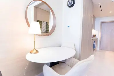 a white table and chairs in a room with a mirror at Scenic Studio at Palm Tower in Dubai