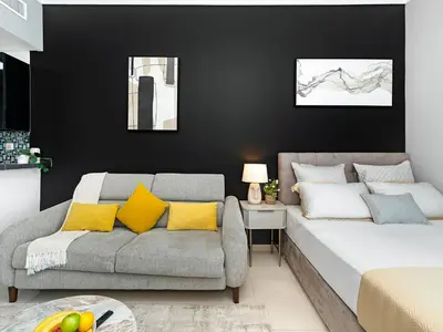 a living room with a couch and a bed at Bright & Stylish Studio with Marina Views in Dubai