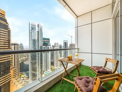 a balcony with a table and chairs and a view of the city at Bright & Stylish Studio with Marina Views in Dubai