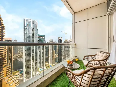 a balcony with two chairs and a table with a view at Bright & Stylish Studio with Marina Views in Dubai