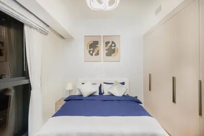 a bedroom with a bed with blue and white sheets at Iconic Views 2BR Burj Khalifa and Fountain in Dubai
