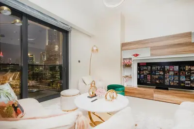a living room with white furniture and a large window at Iconic Views 2BR Burj Khalifa and Fountain in Dubai
