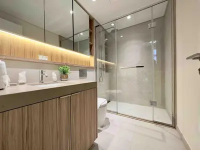 a bathroom with a toilet and a glass shower at Spacious & Modern 1BR in Wilton Terraces in Dubai