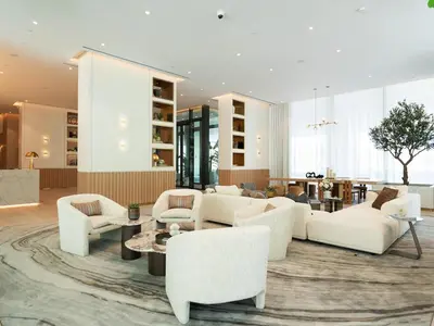 a living room with white furniture and a table at Modern Neoclassical 1BR - Berkeley Place Dubai in Dubai