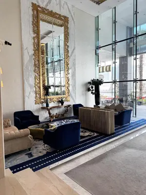 a living room with a mirror and blue chairs at Luxury Studio in Heart of Dubai in Dubai