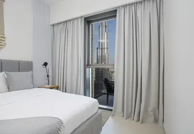 a bedroom with a bed and a large window at A&S Properties Downtown Dubai in Dubai