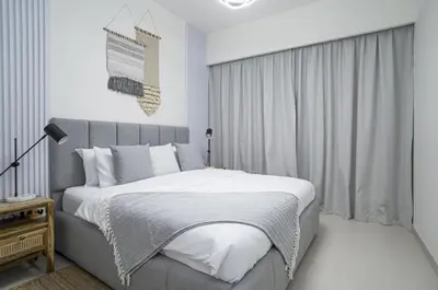 a white bedroom with a large bed and a window at A&S Properties Downtown Dubai in Dubai