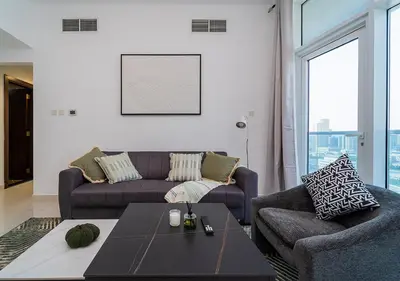 a living room with a couch and a table at Lux JVT Resort Pools Spa Gym Kids Play in Dubai