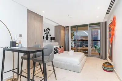 a living room with a bed and a table and chairs at Elegant Designer Studio8 Min Walk to Burj Khalifa in Dubai