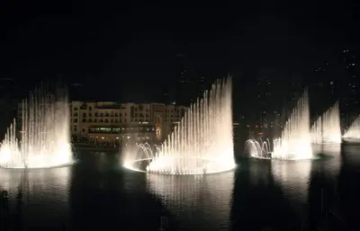 a group of fountains in the water at night at Elegant Designer Studio8 Min Walk to Burj Khalifa in Dubai