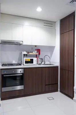 a kitchen with wooden cabinets and a microwave at Cozy Burj Khalifa View Retreat in Dubai