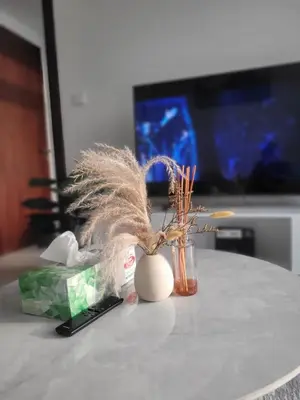 a table with a vase with feathers in it at Cozy Burj Khalifa View Retreat in Dubai