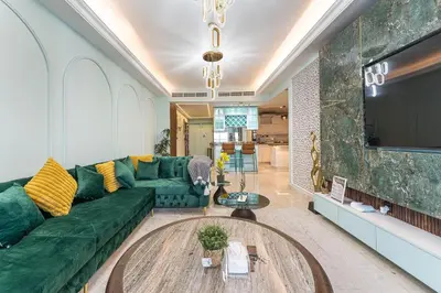a living room with a green couch and a tv at Homeeza Luxury 2BR Apartment Sea Views Dubai Marina in Dubai