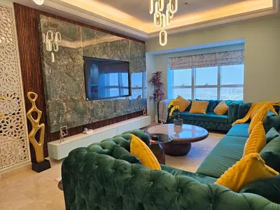 a living room with a green couch and a tv at Homeeza Luxury 2BR Apartment Sea Views Dubai Marina in Dubai