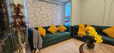 a living room with a green couch with yellow pillows at Homeeza Luxury 2BR Apartment Sea Views Dubai Marina in Dubai