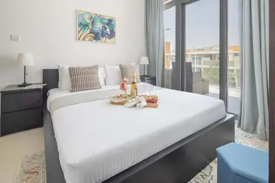 a bedroom with two beds and a large window at Frank Porter - Avencia, Damac Hills 2 in Dubai