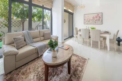 a living room with a couch and a table at Frank Porter - Avencia, Damac Hills 2 in Dubai