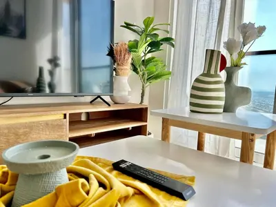 a living room with a remote control on a table at Homes2Retreat - Golf & Desert Views - Luxe 1BR Escape in Dubai