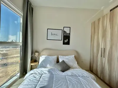 a bedroom with a bed and a window at Homes2Retreat - Golf & Desert Views - Luxe 1BR Escape in Dubai