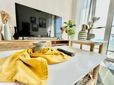 a yellow blanket sitting on a table in a living room at Homes2Retreat - Golf & Desert Views - Luxe 1BR Escape in Dubai