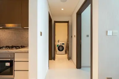 a hallway leading into a kitchen with a washing machine at KeyRock - 1BR with Sea & Palm Jumeirah Views in Dubai