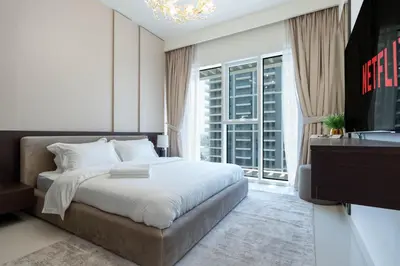 a bedroom with a bed and a tv and a window at KeyRock - 1BR with Sea & Palm Jumeirah Views in Dubai