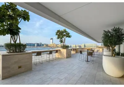 a patio with tables and chairs and a view of the water at KeyRock - 1BR with Sea & Palm Jumeirah Views in Dubai