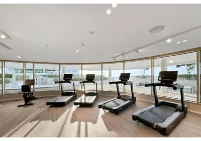 a gym with a row of treadmills and windows at KeyRock - 1BR with Sea & Palm Jumeirah Views in Dubai