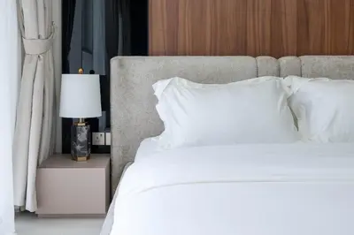 a bed with white sheets and a lamp on a table at KeyRock - Sea View Stay with Pool Access in Dubai
