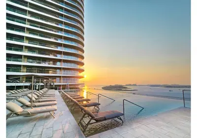 a view of a building with chairs and a pool at KeyRock - Sea View Stay with Pool Access in Dubai