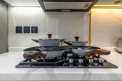 two pots and pans on a stove in a kitchen at ALiving Modern Studio I Private Pool I Opalz by Danube- 1308 in Dubai