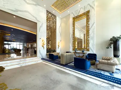 a lobby with blue chairs and a large mirror at GuestReady - Canal View | Studio + Sofa Bed in Dubai