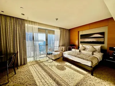 a hotel room with a bed and a large window at Kempinski Central Avenue Studio Burj view in Dubai