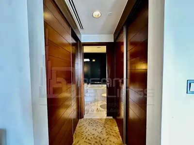 a hallway with wood paneling and a wooden door at Kempinski Central Avenue Studio Burj view in Dubai