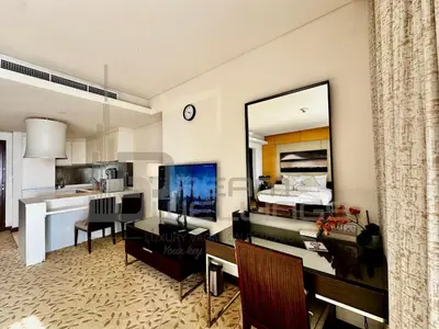 a living room with a desk and a large mirror at Kempinski Central Avenue Studio Burj view in Dubai