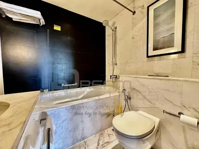 a bathroom with a toilet and a bath tub at Kempinski Central Avenue Studio Burj view in Dubai