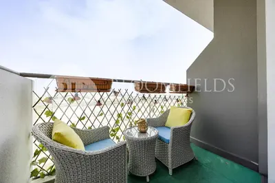 a balcony with wicker chairs and a table at Bloomfields Stylish Stu Laya Heights in Dubai