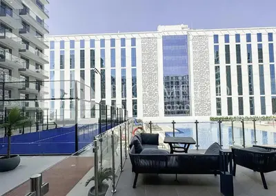 a balcony with chairs and a table and a building at Bloomfields Stylish Stu Laya Heights in Dubai
