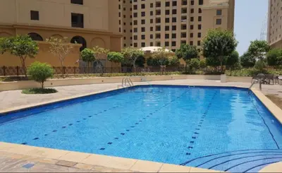 a large swimming pool in the middle of a building at Ain Dubai & Sea Views 2BR Unit Close to Beach, Shams 4, Jumeirah Beach Residence by Deluxe Holiday Homes in Dubai
