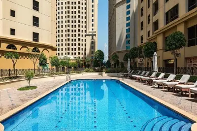 a large swimming pool with lounge chairs and buildings at Ain Dubai & Sea Views 2BR Unit Close to Beach, Shams 4, Jumeirah Beach Residence by Deluxe Holiday Homes in Dubai