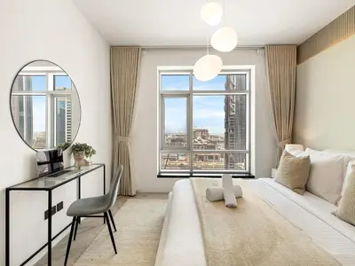 a bedroom with a large bed and a mirror at Kensington Stylish 1BR at The Lofts East Downtown in Dubai