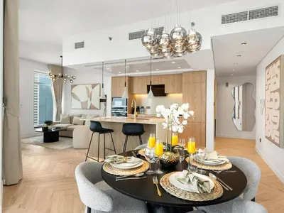 a kitchen and living room with a table and chairs at Kensington Stylish 1BR at The Lofts East Downtown in Dubai