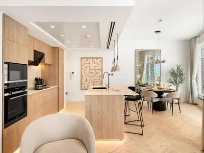 a kitchen and living room with a table and chairs at Kensington Stylish 1BR at The Lofts East Downtown in Dubai