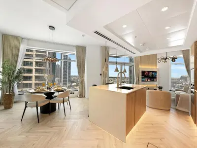 a kitchen and living room with a table and chairs at Kensington Stylish 1BR at The Lofts East Downtown in Dubai
