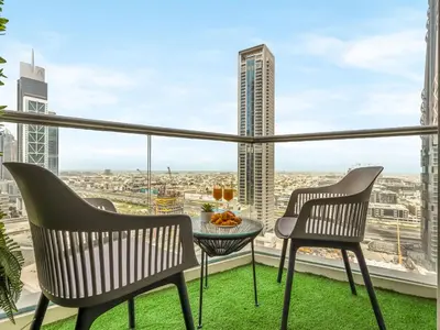 a balcony with a table and chairs and a view of a city at Kensington Stylish 1BR at The Lofts East Downtown in Dubai