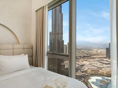 a bedroom with a bed and a view of a city at Grande Signature Premium Stay in Dubai
