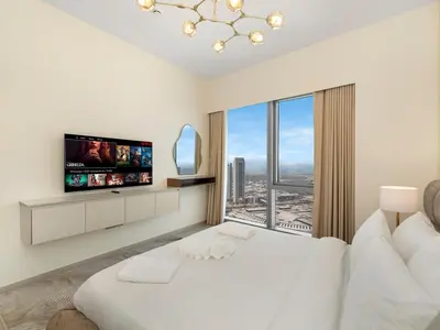 a white bedroom with a large white bed and a large window at Grande Signature Premium Stay in Dubai