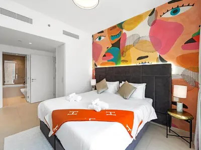 a bedroom with a large bed with a painting on the wall at Stunning 2BR Dubai Mall Pool Gym Burj Khalifa in Dubai