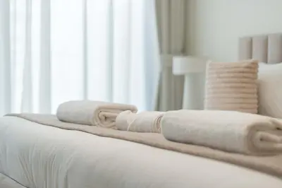 a bed with white blankets and pillows on it at TRPS - Binghatti Amber, JVC - Luxury 1BR Haven - Prime Location in Dubai