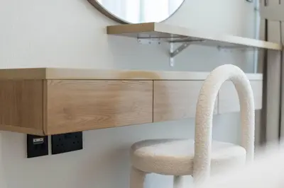 a stool in front of a vanity with a mirror at TRPS - Binghatti Amber, JVC - Luxury 1BR Haven - Prime Location in Dubai